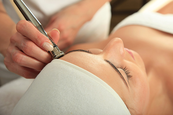 female patient receiving microdermabrasion skin care treatment