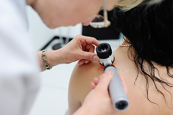 A female patient  receiving a skin cancer screening procedure
