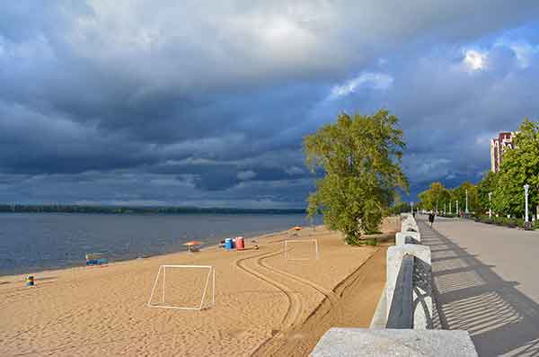 sandy beach with dark clouds forming in the sky