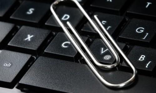 cloe up shot of a paper clip laying on top of a computer keyboard