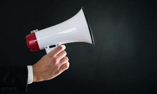 stock image of businessman's hand holding a megaphone 