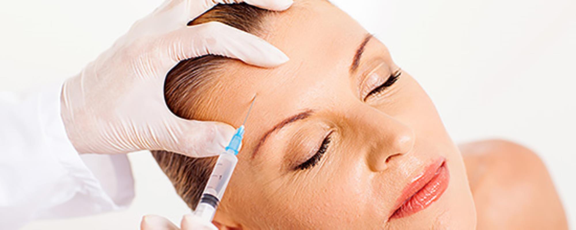 Woman with eyes closed and calm expression receiving an injection applied directly to the forehead